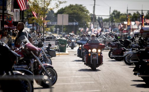 People ride through downtown Sturgis, S.D., during the 80th annual Sturgis Motorcycle Rally on Monday, Aug. 10, 2020.