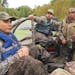 Trevor Montez, center, steers his mud boat through a backwater on the Mississippi River on his family's return from the state duck season opener north
