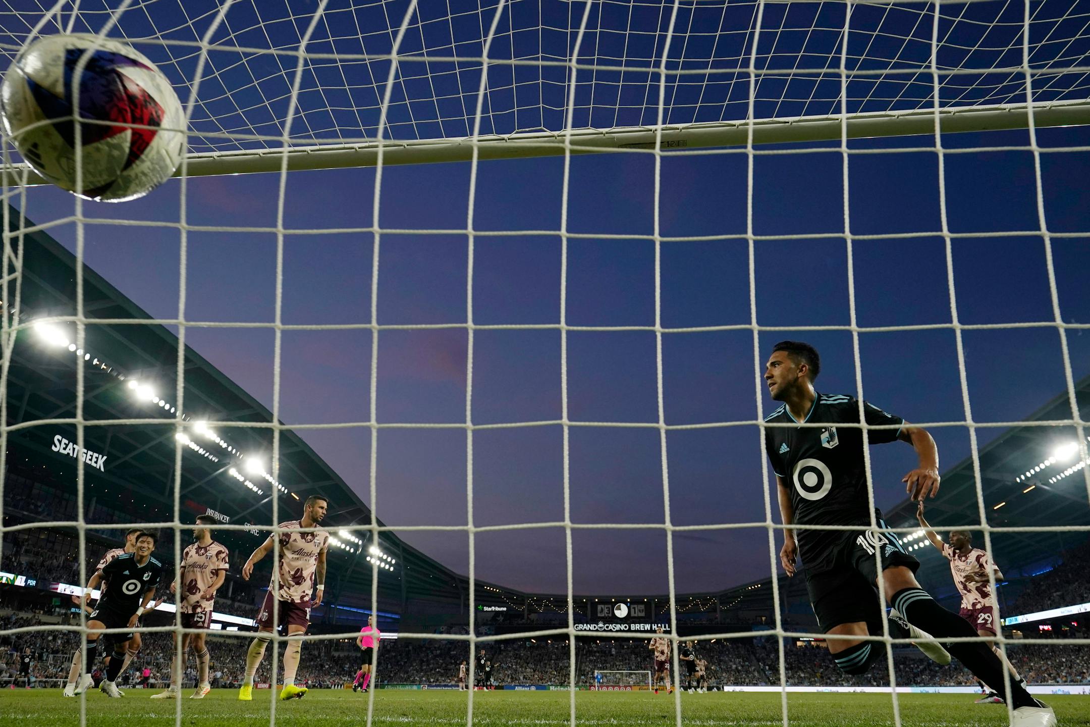 Minnesota United midfielder Emanuel Reynoso, right, scores against the Portland Timbers during the second half of an MLS soccer match Saturday, July 1, 2023, in St. Paul, Minn. (AP Photo/Abbie Parr)