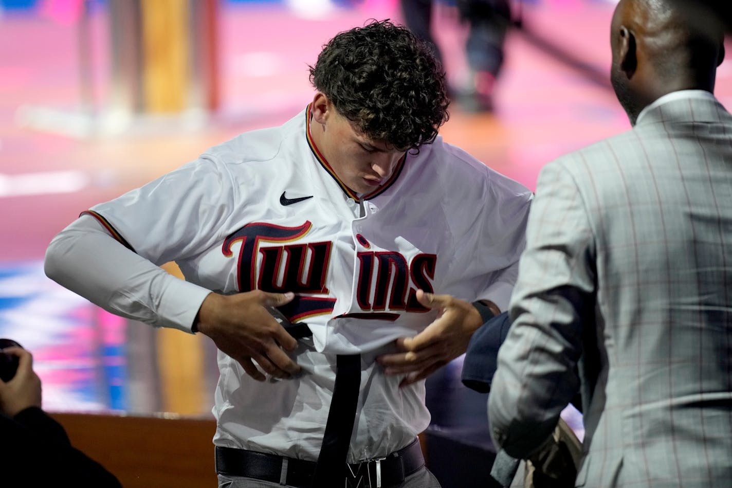 Mainland High School's Chase Petty puts on his jersey after being selected by the Minnesota Twins as the 26th pick in the first round of the 2021 MLB baseball draft, Sunday, July 11, 2021, in Denver. (AP Photo/David Zalubowski)