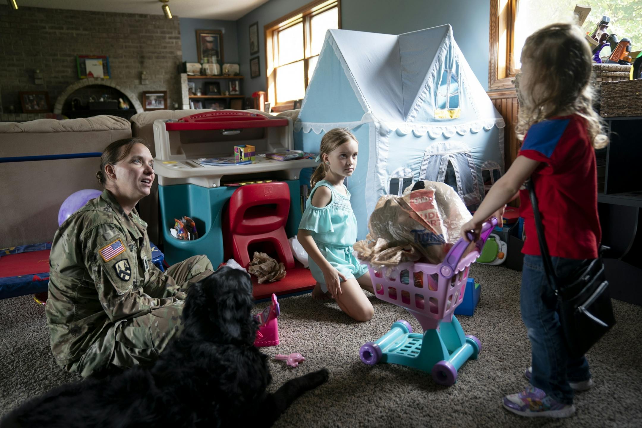 Jeanette Chafee played grocery store with her daughters Madison, 8, and Ally, 3, at home in Scandia, Minn., on Wednesday, September 18, 2019. Chafee was in her uniform after coming home from work.