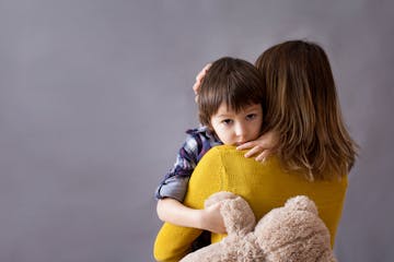 A boy is comforted by his mom.