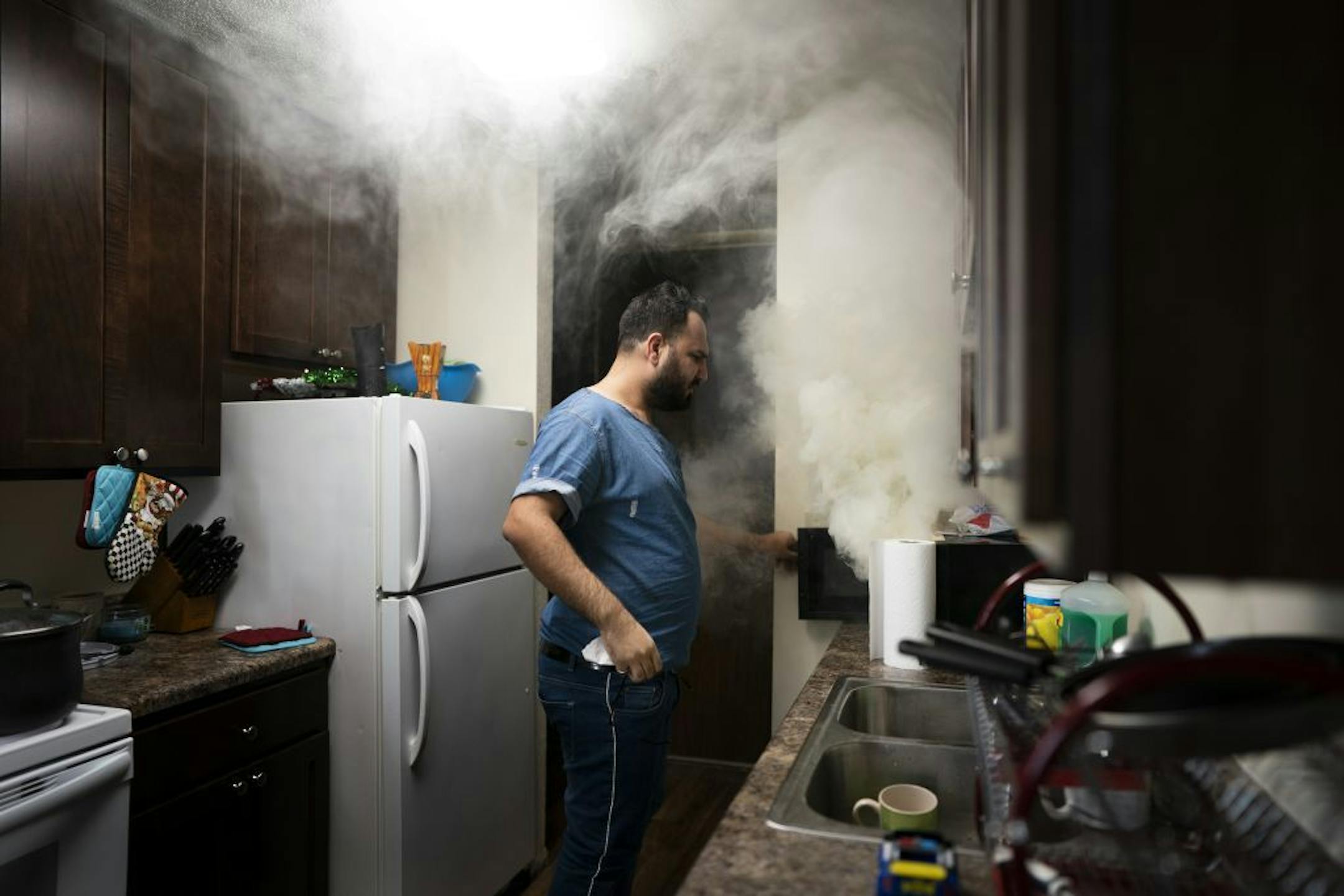 Azhar Al-Rubaie a freelance journalist who fled Basra, Iraq after facing threats for his coverage of the violent protests against the government that drew international headlines in recent months . Azhar recently move to Minnesota and was not familiar with microwaves, he lift a piece of bread in the microwave to long at his friends apartment Thursday January 17, 2019 in Coon Rapids, MN.