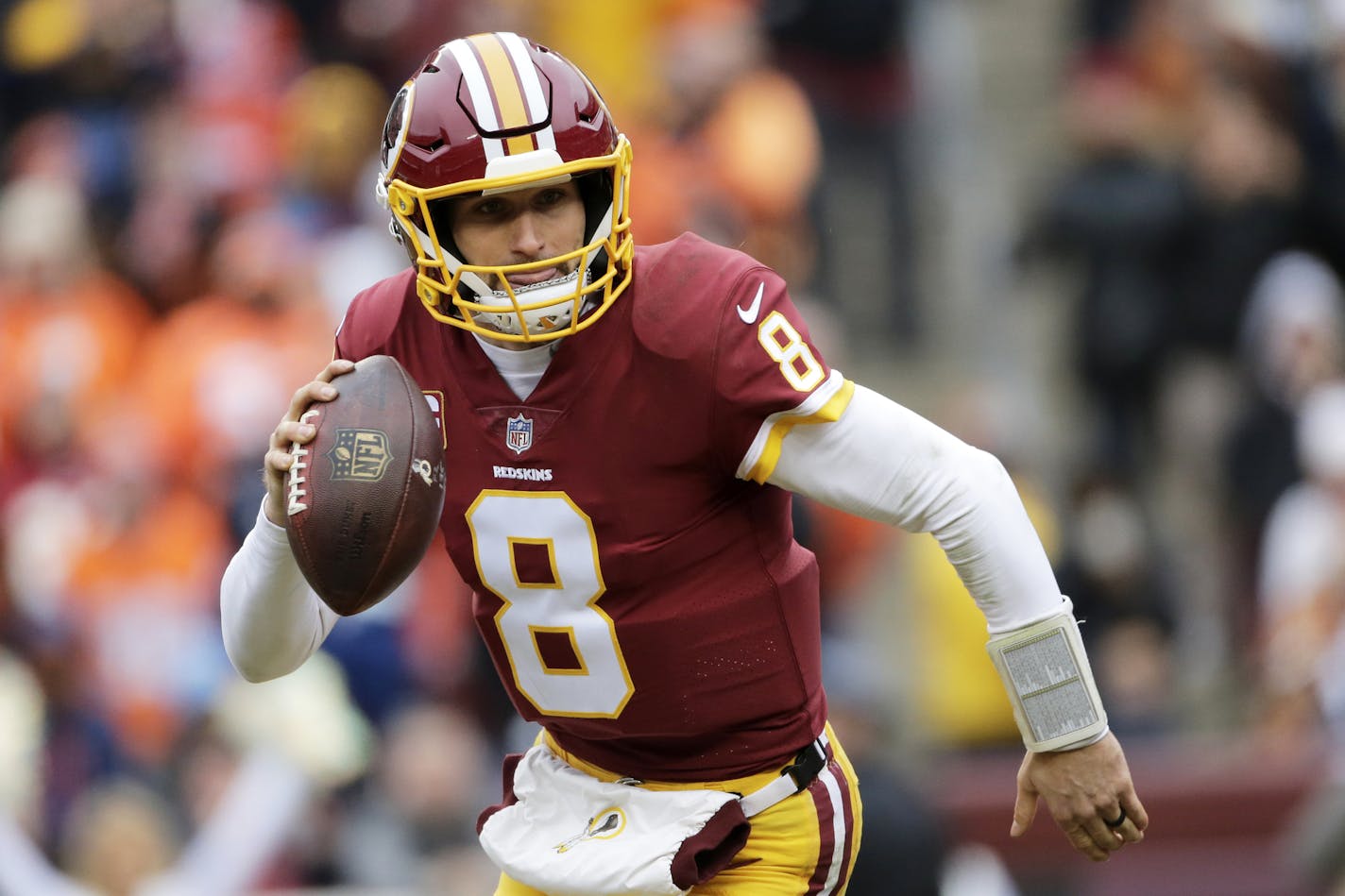 Kirk Cousins scrambles during an NFL football game against the Denver Broncos last season.