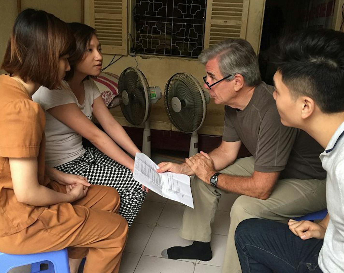 COURTESY GLOBAL VOLUNTEERS. Tom Leach, a volunteer with Global Volunteers in St. Paul, reads to school children in Vietnam.