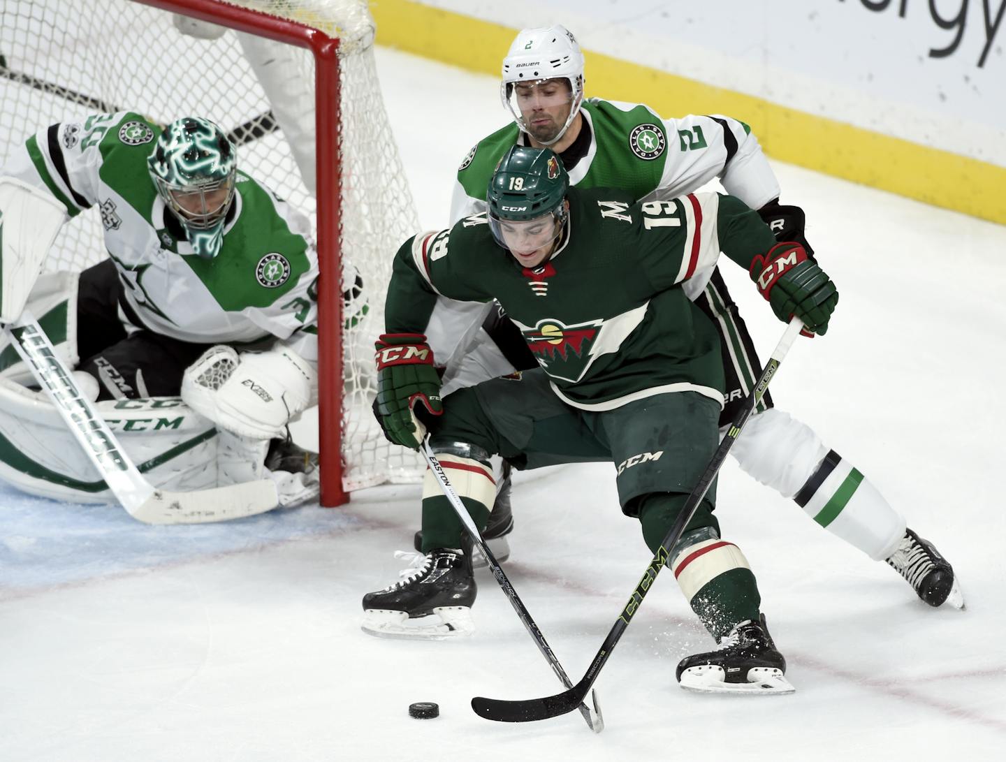 Dallas Stars goalie Ben Bishop (30) watches as Minnesota Wild center Luke Kunin (19) keeps the puck from Stars defenseman Dan Hamhuis (2) during the second period of an NHL preseason hockey game Saturday, Sept. 30, 2017, in St. Paul, Minn. (AP Photo/Hannah Foslien)