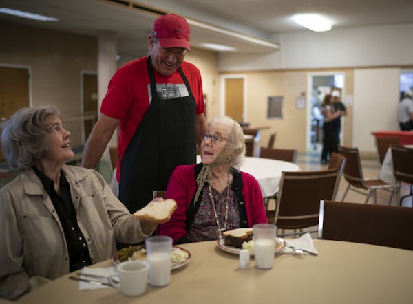 Volunteer Tom Belting visited after he served rib dinners to guests Dolores Schmeidel, left, and Mary Jo Mileski at Loaves & Fishes' Hopkins location.