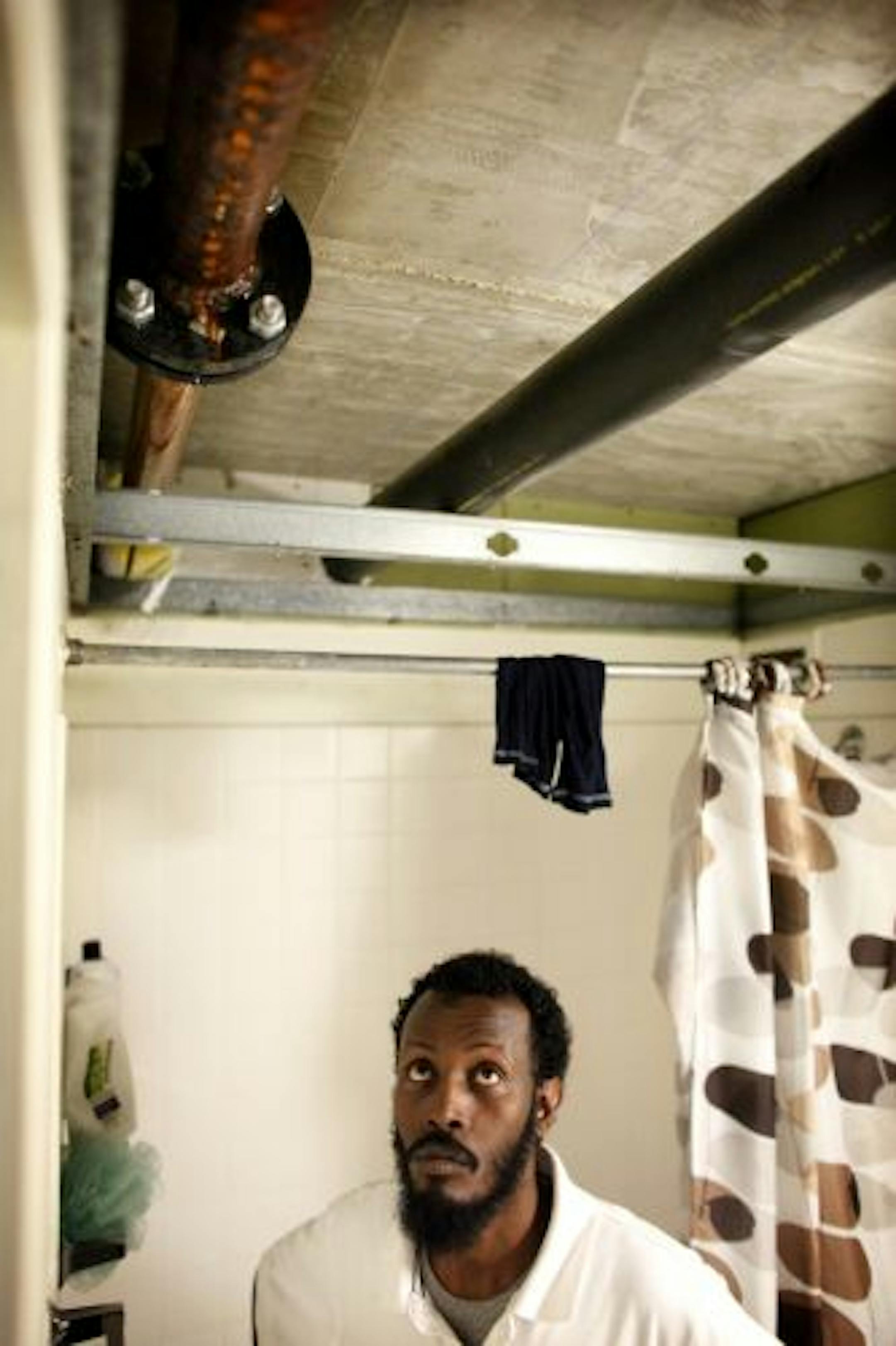 Abdishakur Mohamed has an exposed pipe in his bathroom. Other tenants complain of maintenance problems.