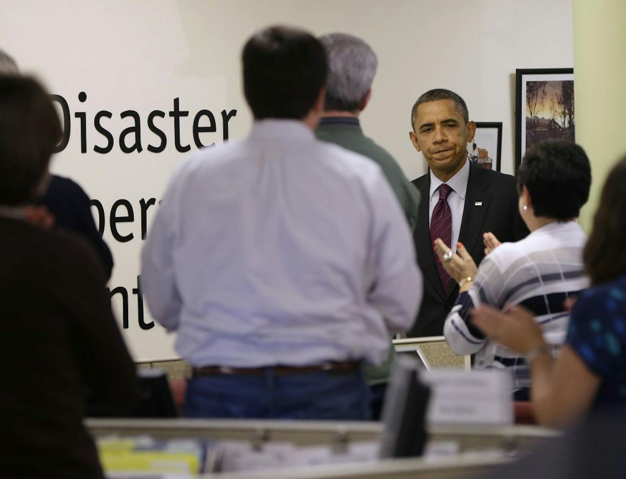President Barack Obama receives applause by workers during the his visit to the Disaster Operation Center of the Red Cross National Headquarter to discuss superstorm Sandy, Tuesday, Oct. 30, 2012, in Washington.