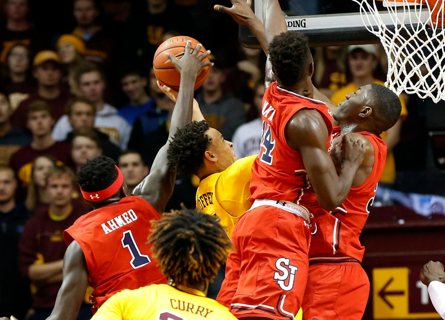 Minnesota's Amir Coffey, center in yellow, is triple-teamed by St. John's defenders on a shot attempt during the first half of an NCAA college basketball game Friday, Nov. 18, 2016, in Minneapolis. (AP Photo/Jim Mone)