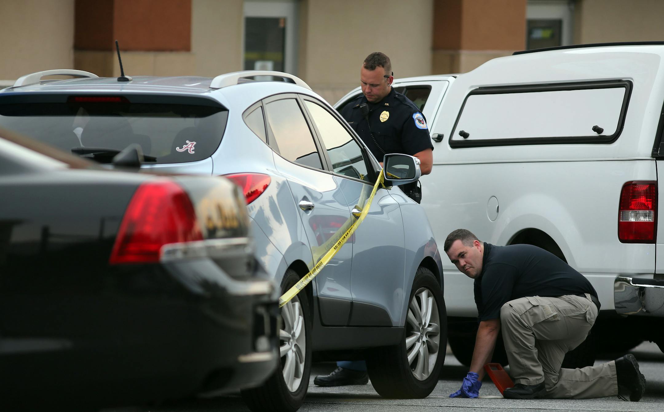 In this Wednesday, June 18, 2014 file photo Cobb County police investigate an SUV where a toddler died near Marietta, Ga., when the father forgot to drop his child off at day care and went to work. Newly released court records show police want to learn about the health of the toddler in the months before he died of heat exposure in his father's car near Atlanta. Search warrants and affidavits released Monday, July 7, 2014 show that investigators are seeking medical records for 22-month-old Coope