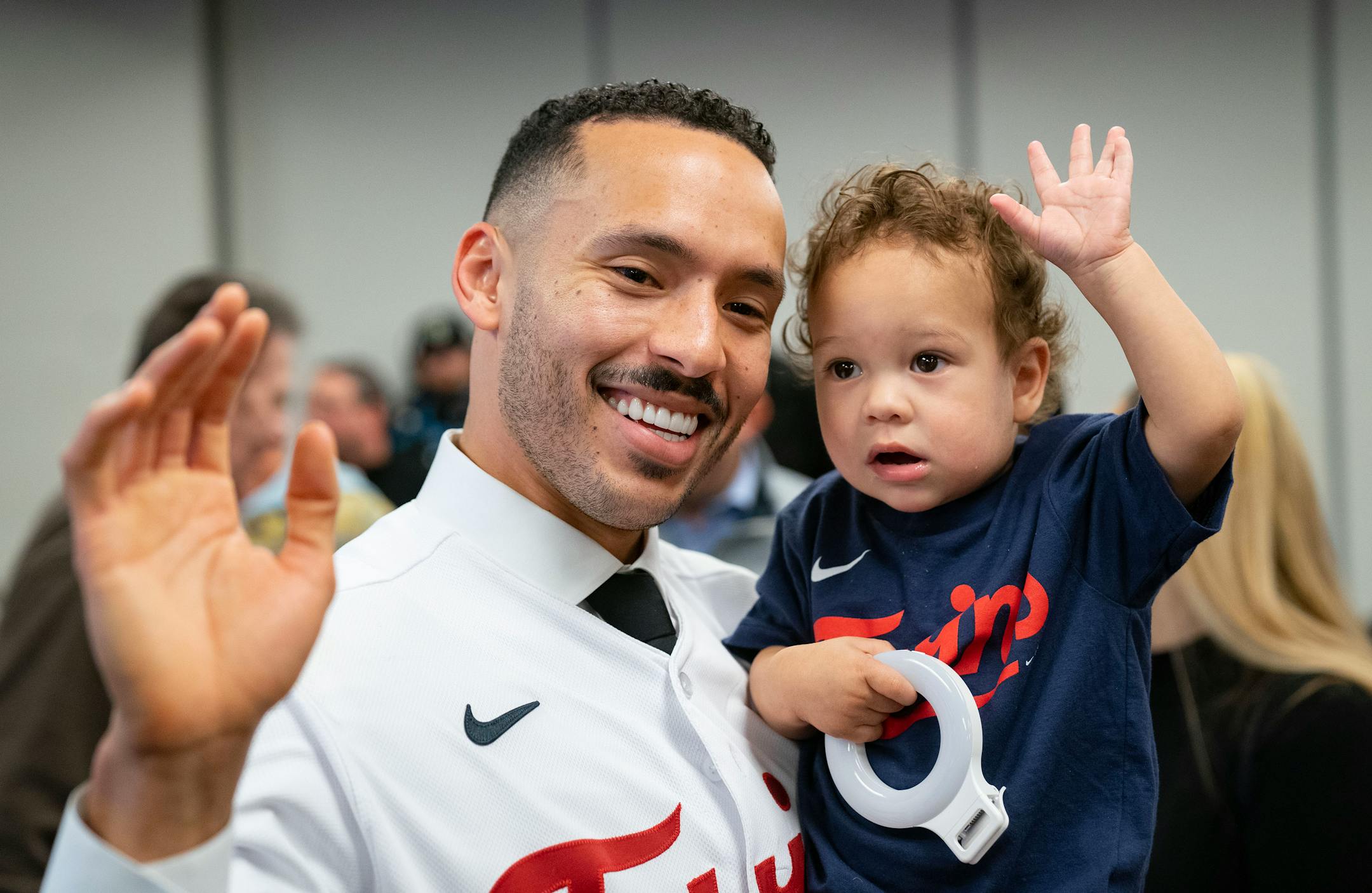 Minnesota Twins shortstop Carlos Correa and his son, Kylo, 1, wave to the cameras after a press conference.