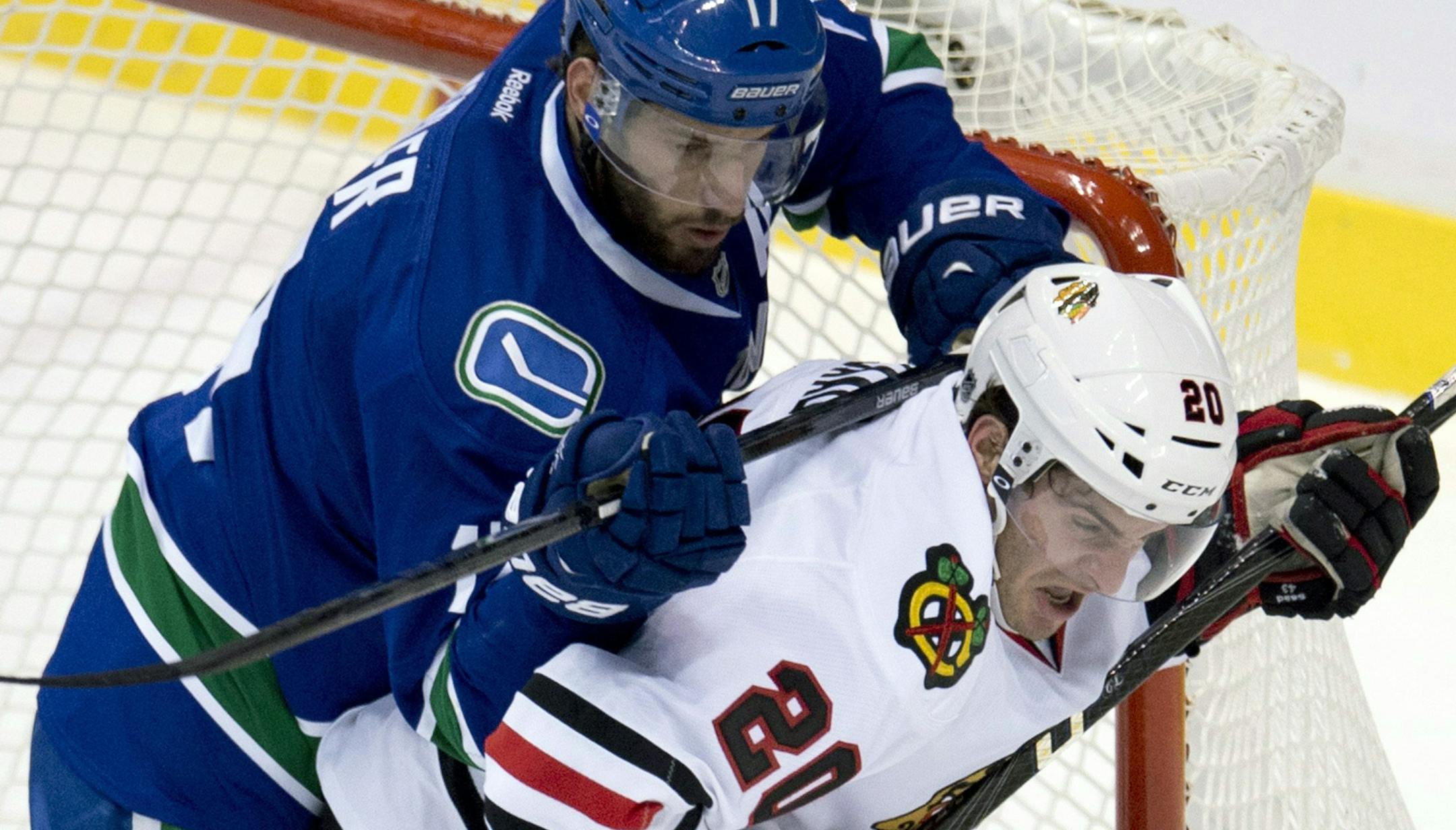 Vancouver Canucks center Ryan Kesler (17) tries to clear Chicago Blackhawks left wing Brandon Saad (20) from in front of the Canucks net during the first period of an NHL hockey game in Vancouver, B.C. on Monday, April 22, 2013. (AP Photo/The Canadian Press, Jonathan Hayward)