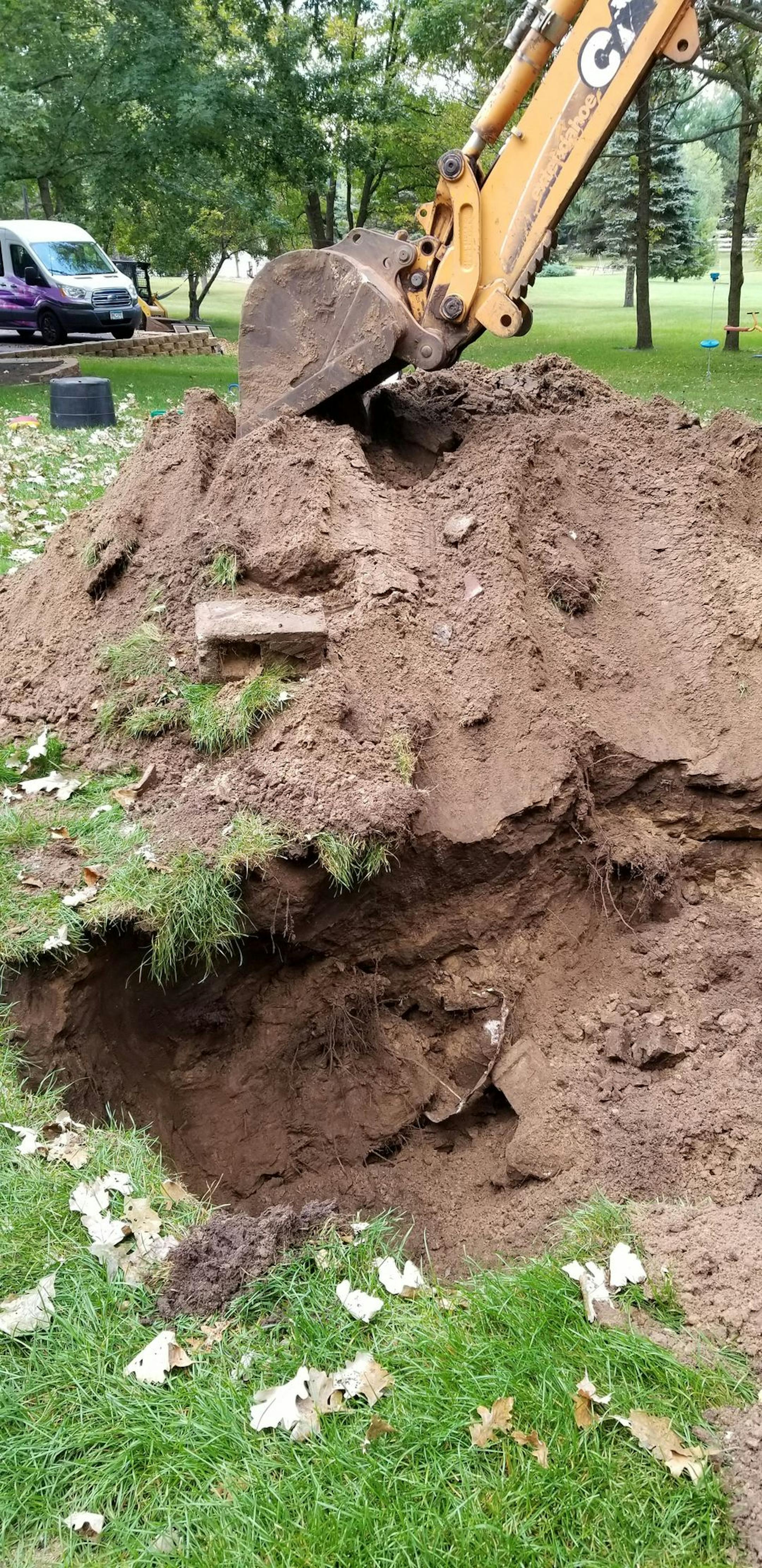 Under the sinkhole, a contractor found pipes, chunks of burned wood and the foundation of a house he believes probably burned down and was buried long ago. The bill to fill in a house-sized sinkhole could top $15,000, Carrie Edberg was told.