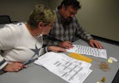 Kathy Cunnien and Dave Dalton examine absentee ballots on Election Day at the Washington County Government Center. The county received about 10,400 re