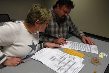 Kathy Cunnien and Dave Dalton examine absentee ballots on Election Day at the Washington County Government Center. The county received about 10,400 re