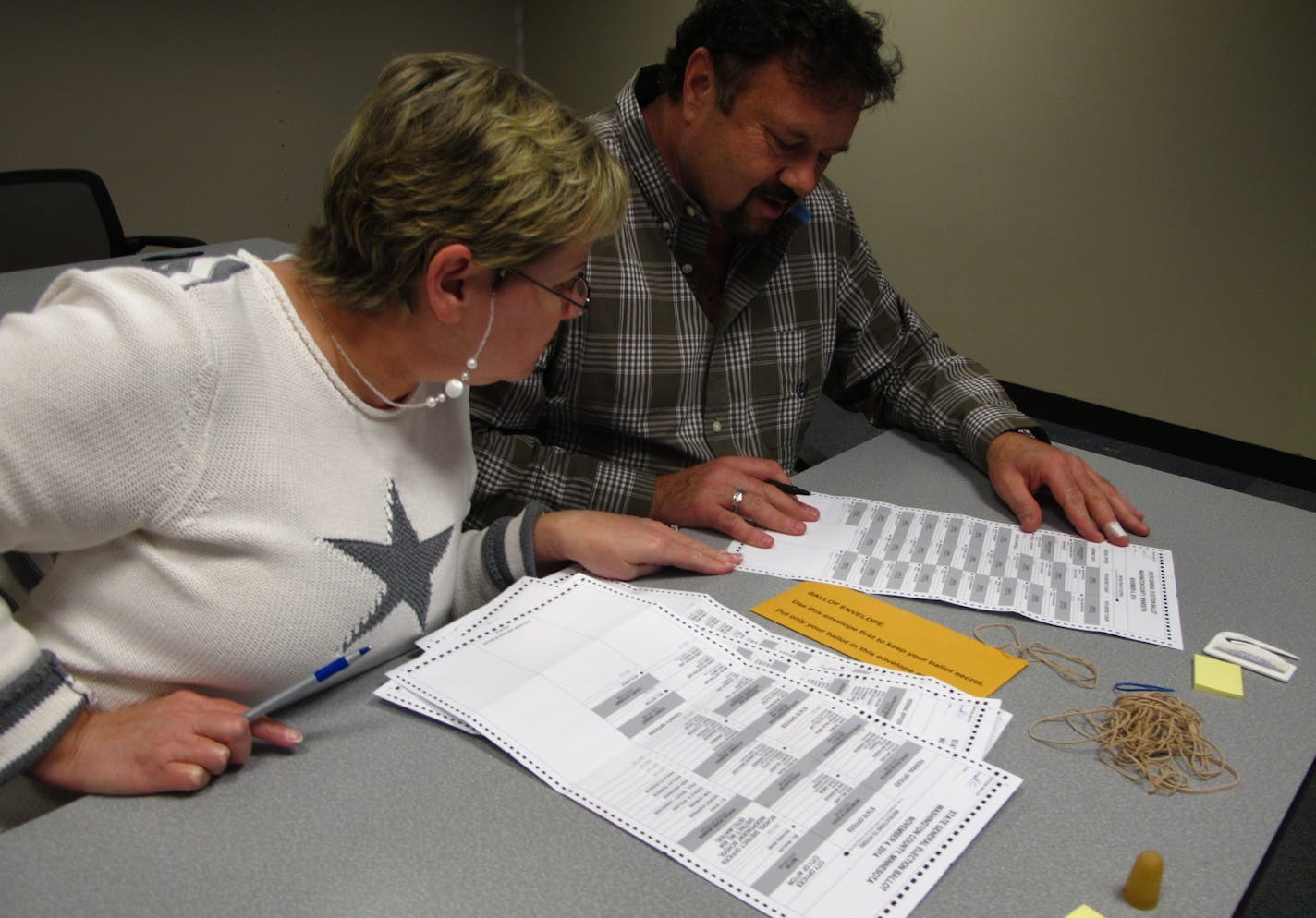 Kathy Cunnien and Dave Dalton examine absentee ballots on Election Day at the Washington County Government Center. The county received about 10,400 requests for ballots.