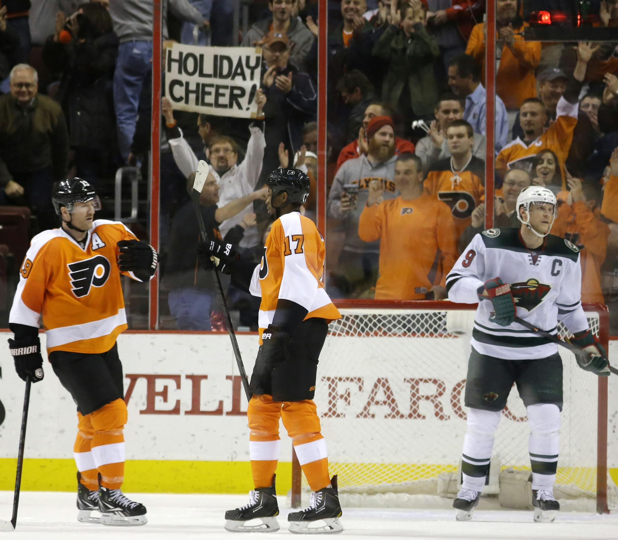 Philadelphia Flyers' Scott Hartnell, left, and Wayne Simmonds, center, celebrate after Simmonds' empty-net goal as Minnesota Wild's Mikko Koivu, of Finland, skates by during the third period of an NHL hockey game, Monday, Dec. 23, 2013, in Philadelphia. Philadelphia won 4-1. (AP Photo/Matt Slocum)