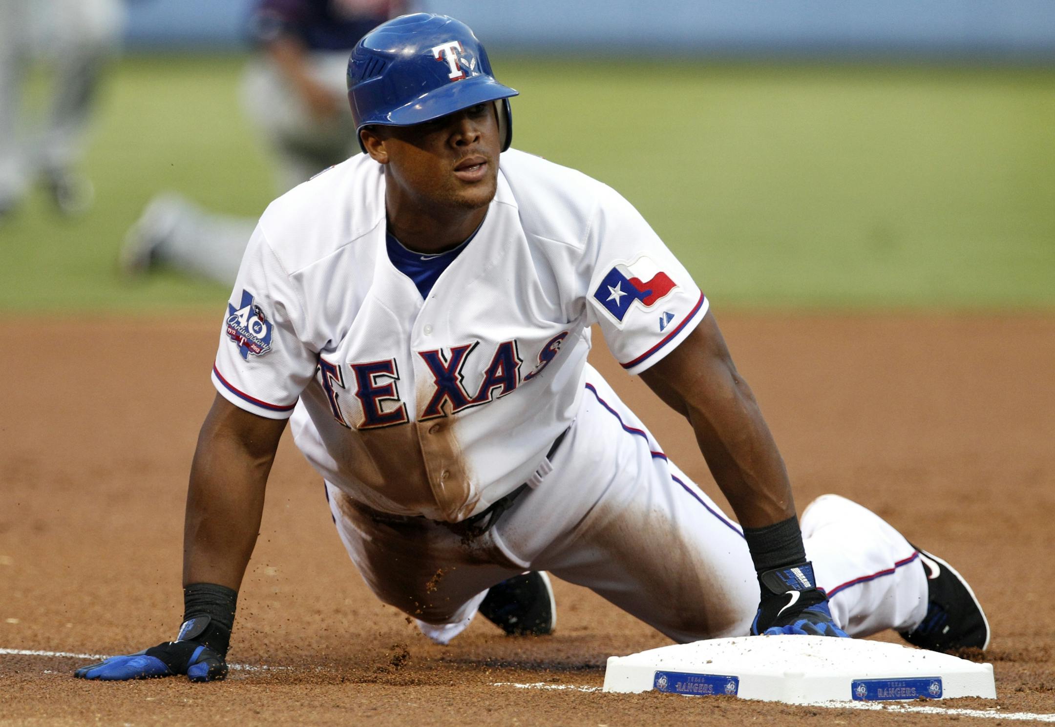 Texas Rangers' Adrian Beltre slides in safely into third on his run-scoring triple off of Minnesota Twins starting pitcher Samuel Deduno in the first inning of a baseball game Friday, Aug. 24, 2012, in Arlington, Texas.
