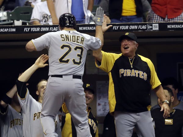 Pittsburgh Pirates manager Clint Hurdle congratulates Travis Snider (23) after Snider's home run during the ninth inning of a baseball game against th