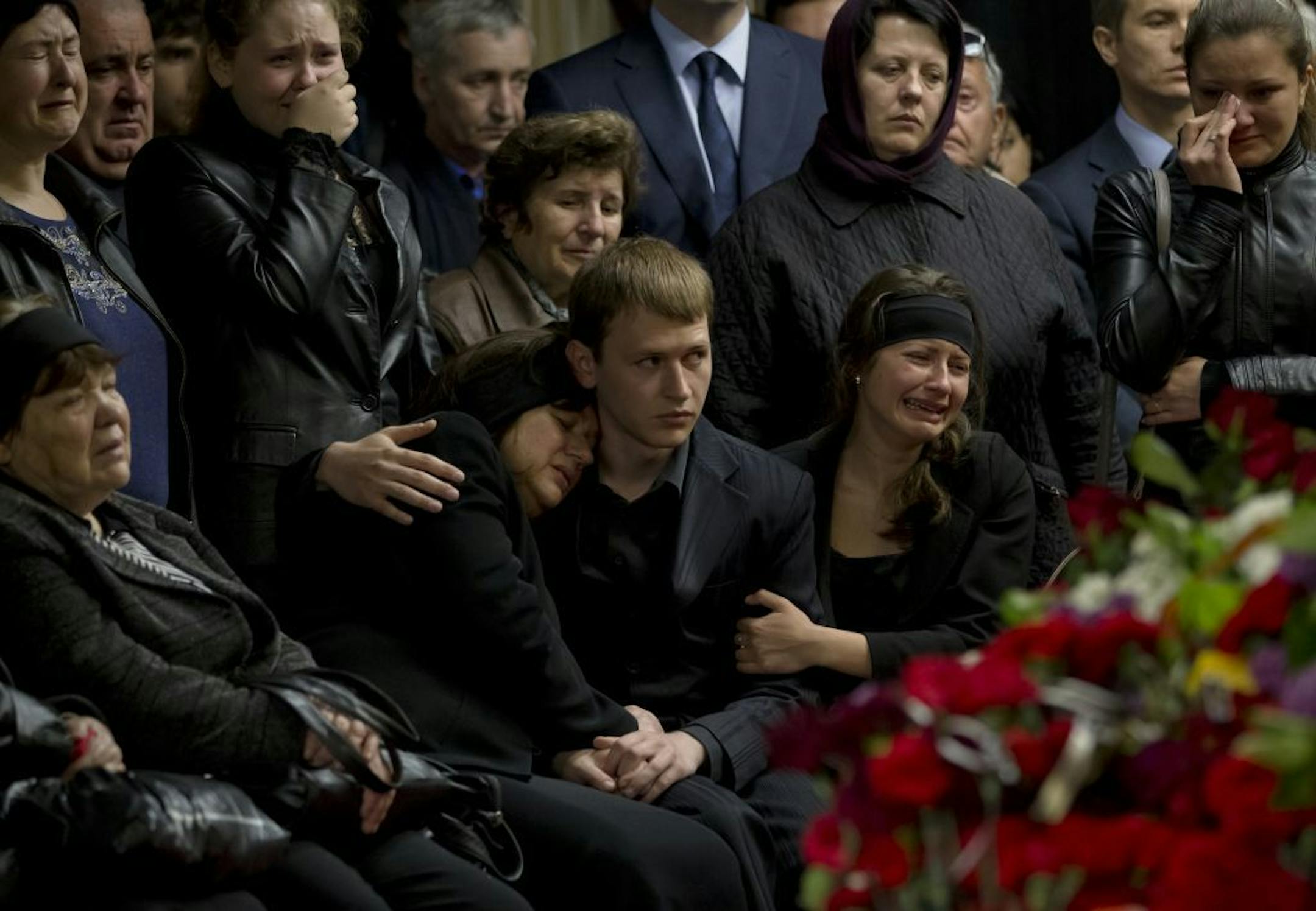 Mourners and family members cry next the coffin of regional parliament member Vyacheslav Markin, in Odessa, Ukraine, Monday, May 5, 2014. Markin, who was known for speaking out against the government in Kiev, was buried as about 300 pro-Russia supporters shouted "Hero, hero!" Markin died Sunday from burns sustained Friday in a fire that followed clashes in Odessa.