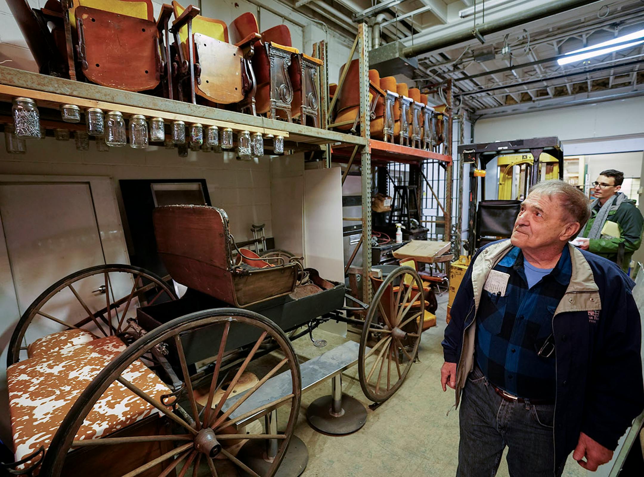 Owner Russ Bauer shows off an old carriage and theatre seating.