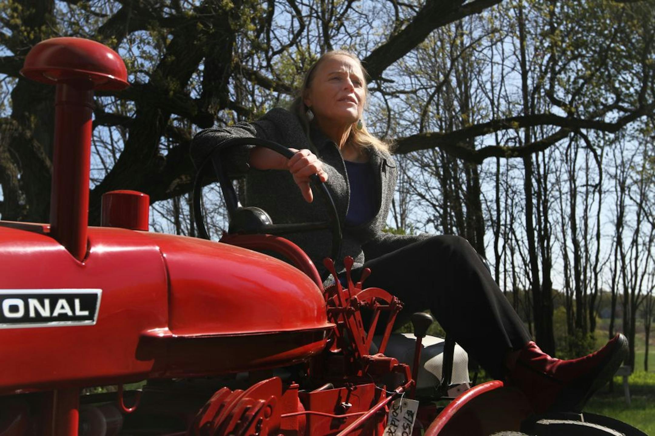 Anita Diffley posed for a portait Tuesday, April 10 on her husband's International Harvest 140 tractor at their Farm in Farmington, Minn.