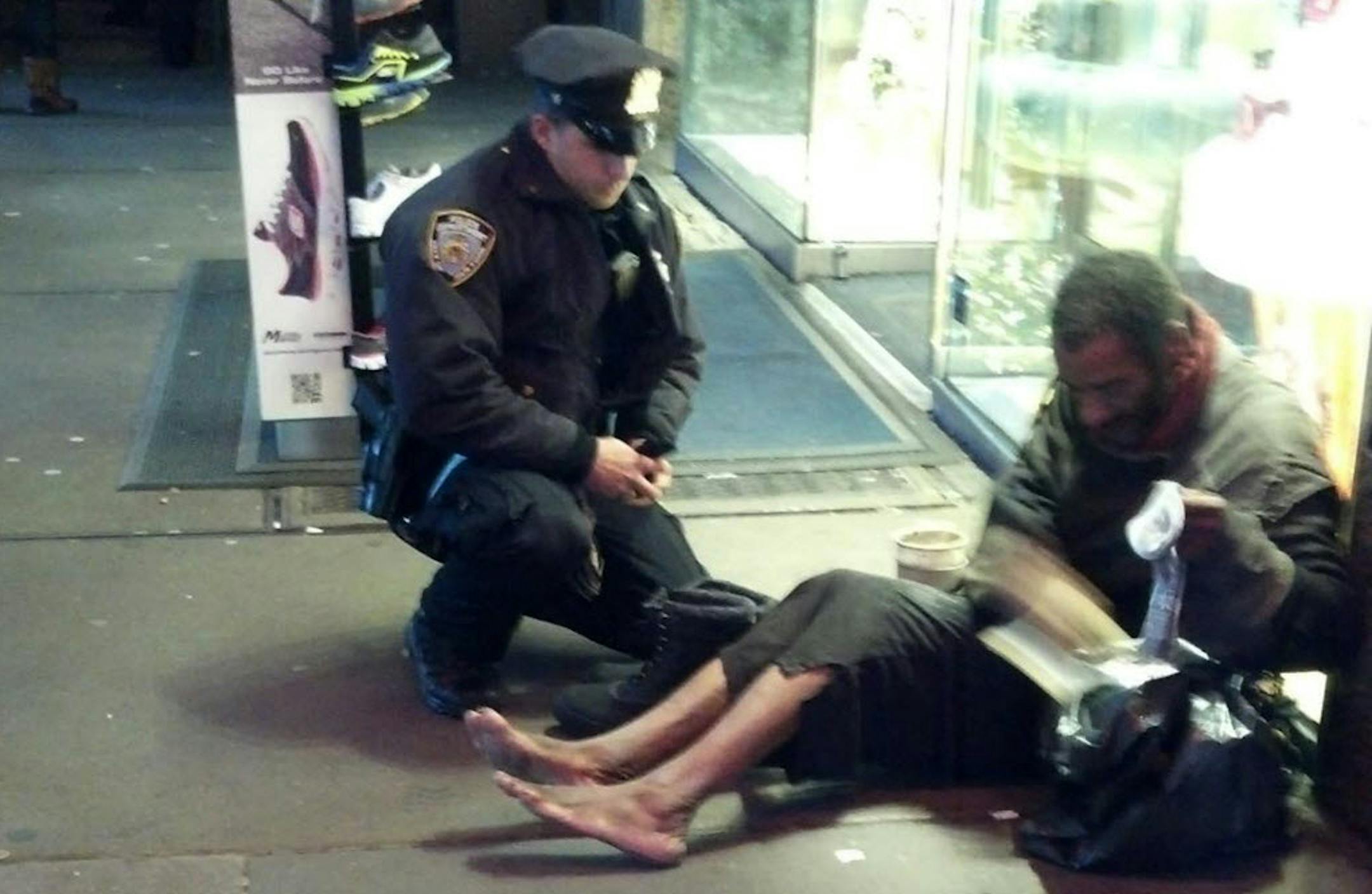 Nov. 14: New York City Police Officer Larry DePrimo presents a barefoot homeless man in New York's Time Square with boots.