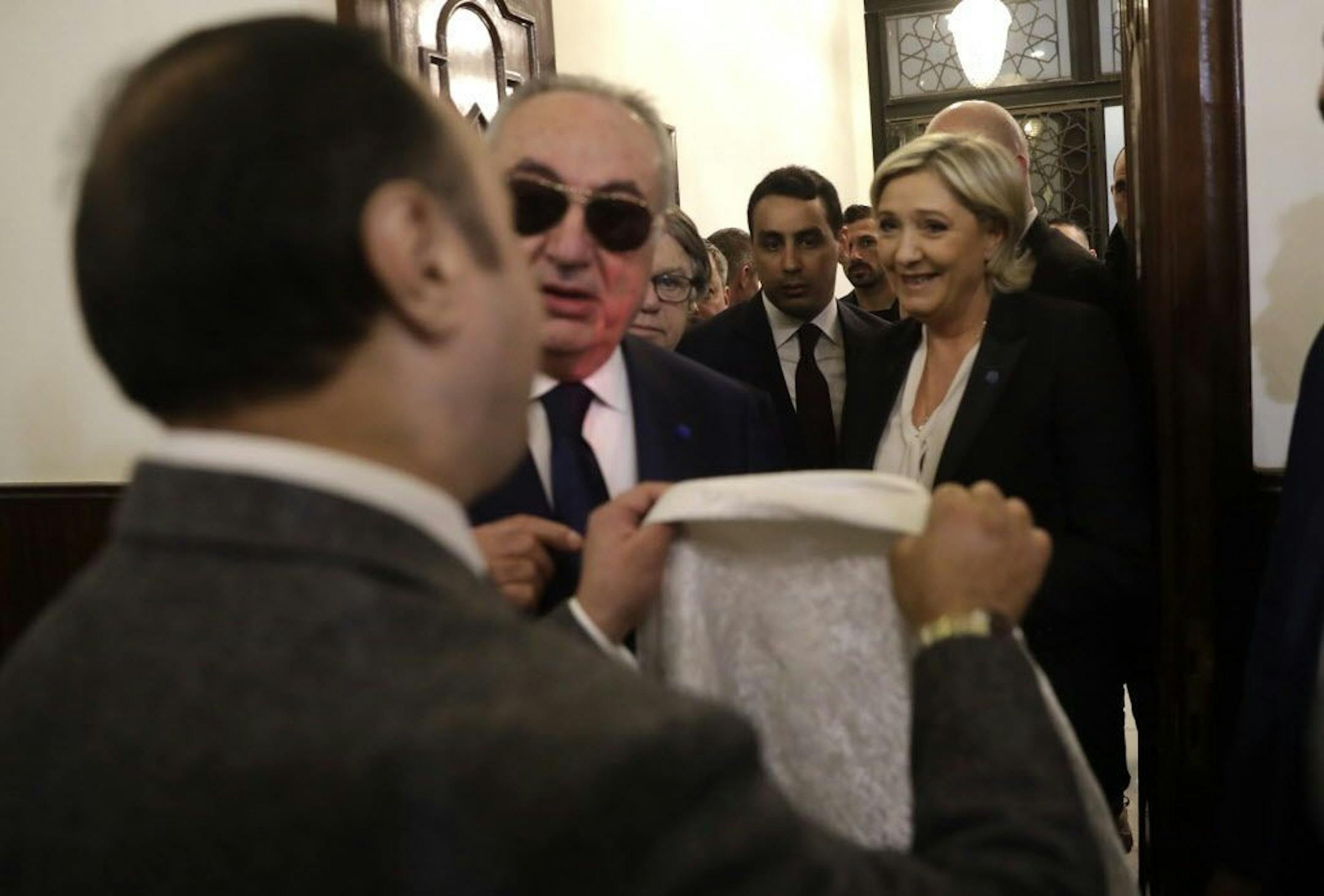 An aide of Lebanon's Grand Mufti Sheikh Abdel-Latif Derian, left, gives a head scarf to French far-right presidential candidate Marine Le Pen, right, to wear during her meeting with the Mufti but she refused, upon her arrival at Dar al-Fatwa the headquarters of the Sunni Mufti, in Beirut, Lebanon, Tuesday, Feb. 21, 2017. Le Pen refused to go into a meeting with Lebanon's Grand mufti after his aides asked her to wear a head scarf. Le Pen said she met in the past with the Grand mufti of Egypt's Al