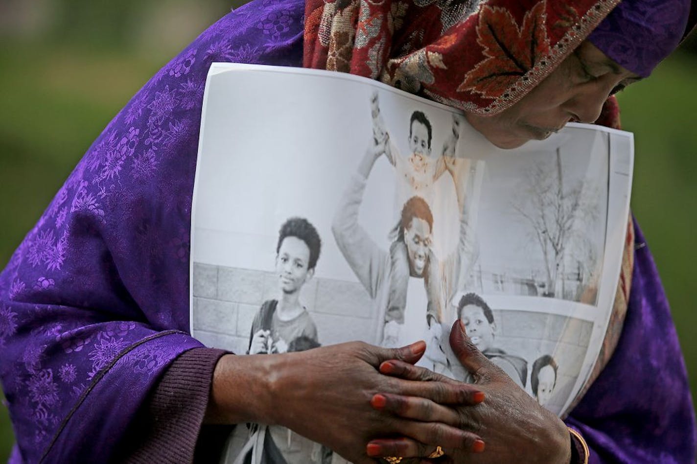 Haqhawo Qaasim, cq, held onto a photo of one of the young men who will stand trial during the opening day of the ISIL recruit trial, in front of the United States Courthouse, Monday, May 9, 2016 in Minneapolis, MN.