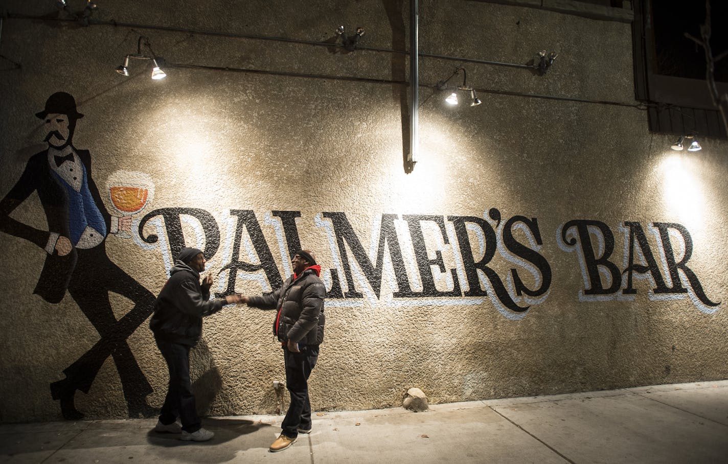 Two Palmer's Bar patrons, who go by the names "R.D." and "C," shook hands before parting ways outside the bar Saturday night. ] (AARON LAVINSKY/STAR TRIBUNE) aaron.lavinsky@startribune.com A profile of Palmer's Bar in West Bank, whose appeal and clientele are a model of coexistence and tradition in the face of trendy cocktail rooms. Photographed Saturday, Dec. 19, 2015 in Minneapolis, Minn.