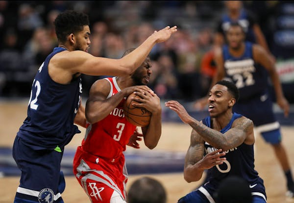 Minnesota Timberwolves center Karl-Anthony Towns (32) and guard Jeff Teague (0) fouled Rockets guard Chris Paul (3) late in the fourth quarter.