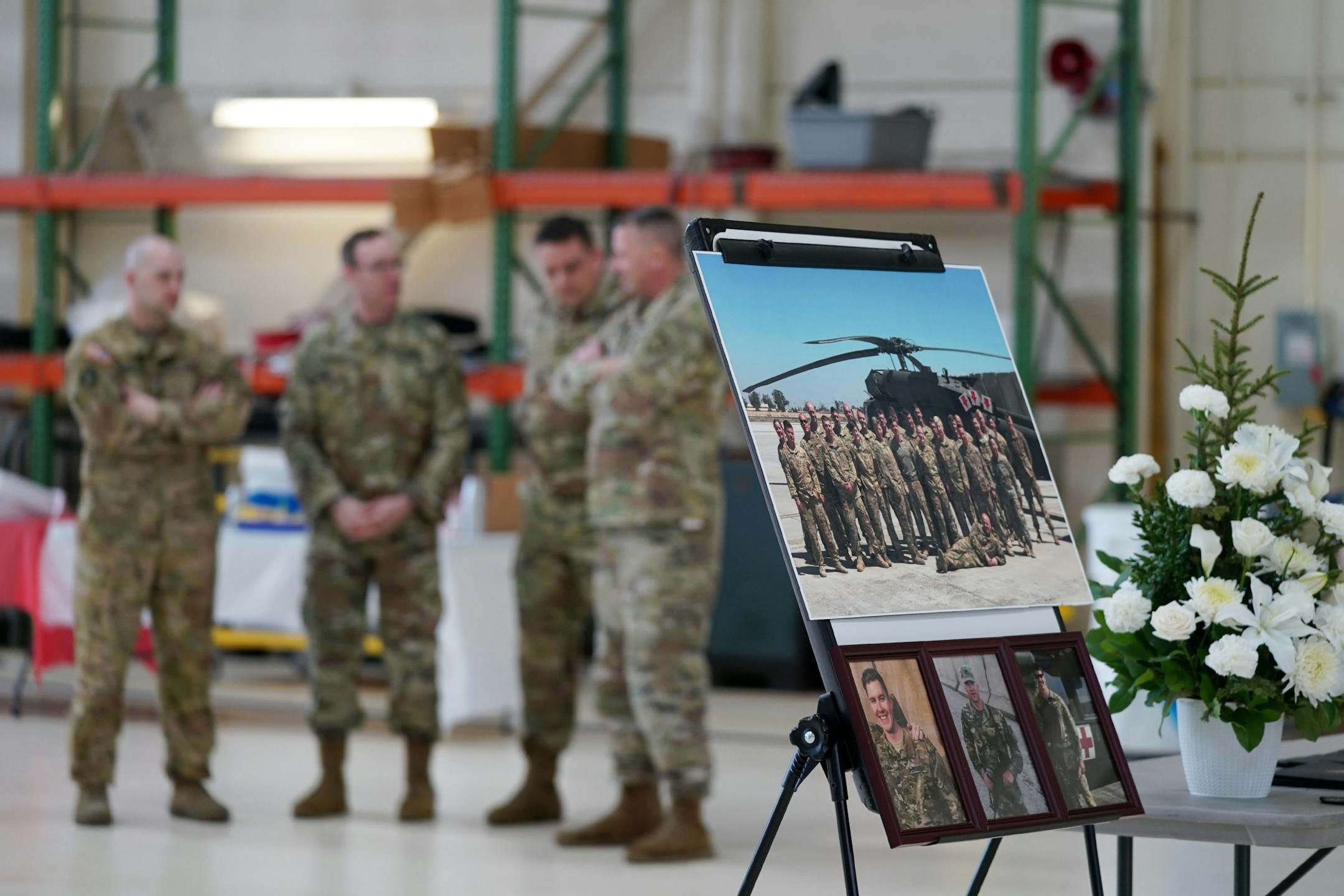 A group photo of the Company C, 2-211th General Support Aviation Battalion, with the deceased solders identifed with arrows at right, sat during Saturday's press conference.