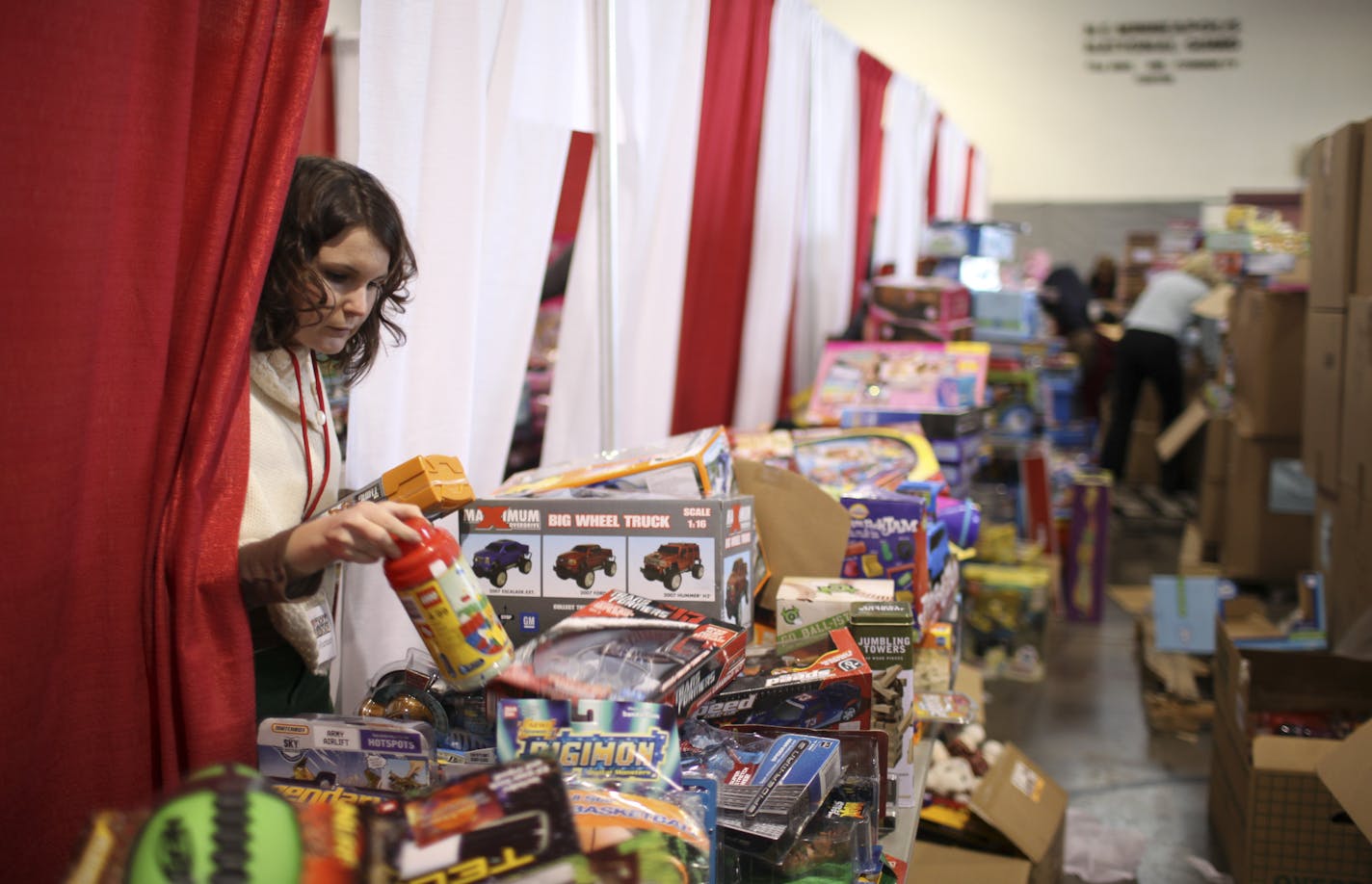 JEFF WHEELER &#xef; jwheeler@startribune.com MINNEAPOLIS - 12/19/08 - This is the time of year when charities get their biggest infusions of cash &#xf1; and also face their biggest demands. On Friday afternoon, the Salvation Army was distributing toys out of the Northeast Minneapolis National Guard Armory to 200 people an hour on average. They'll do it again Saturday and Monday. IN THIS PHOTO: ] Sarah Denney, a volunteer working at the Salvation Army toy distribution site at the National Guard A