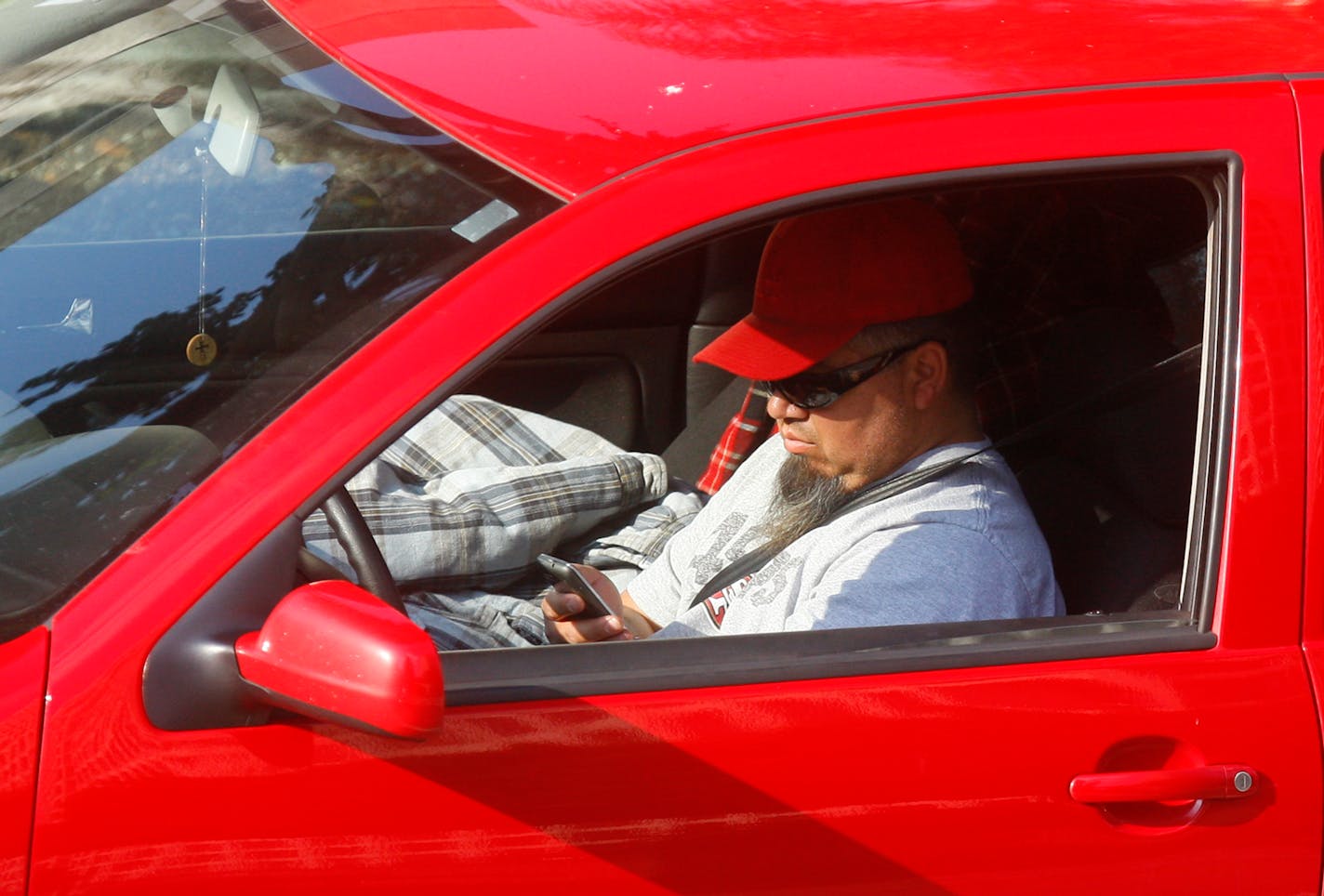 A driver uses his cellphone while driving.