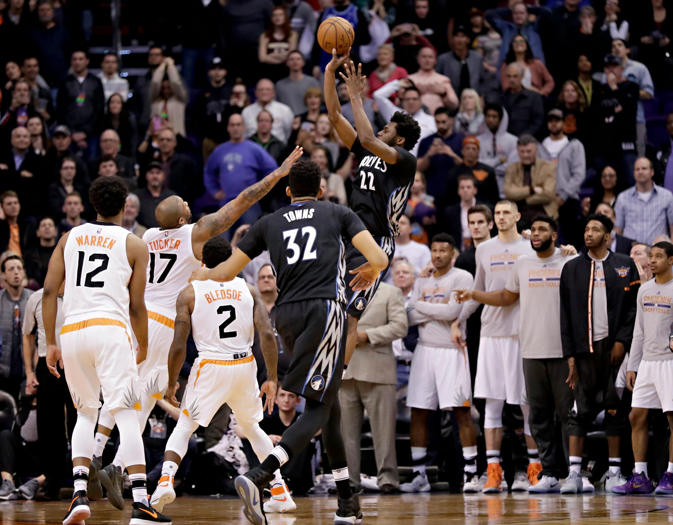 Minnesota Timberwolves forward Andrew Wiggins (22) shoots the game winning basket as Phoenix Suns forward P.J. Tucker (17) defends during the second half of an NBA basketball game, Tuesday, Jan. 24, 2017, in Phoenix. The Timberwolves won 112-111. (AP Photo/Matt York)