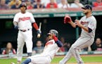 Cleveland's Francisco Lindor, center, scores on a passed ball as pitcher Martin Perez, right, waits during a game in June.