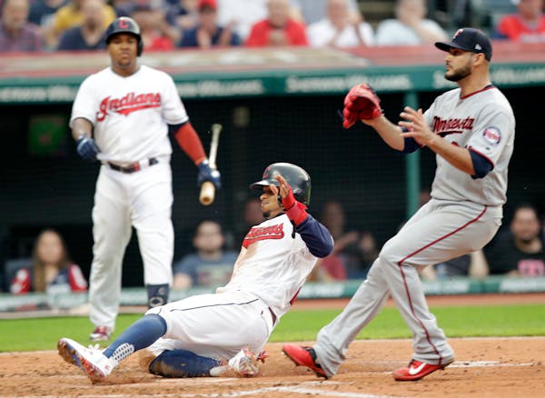 Cleveland's Francisco Lindor, center, scores on a passed ball as pitcher Martin Perez, right, waits during a game in June.
