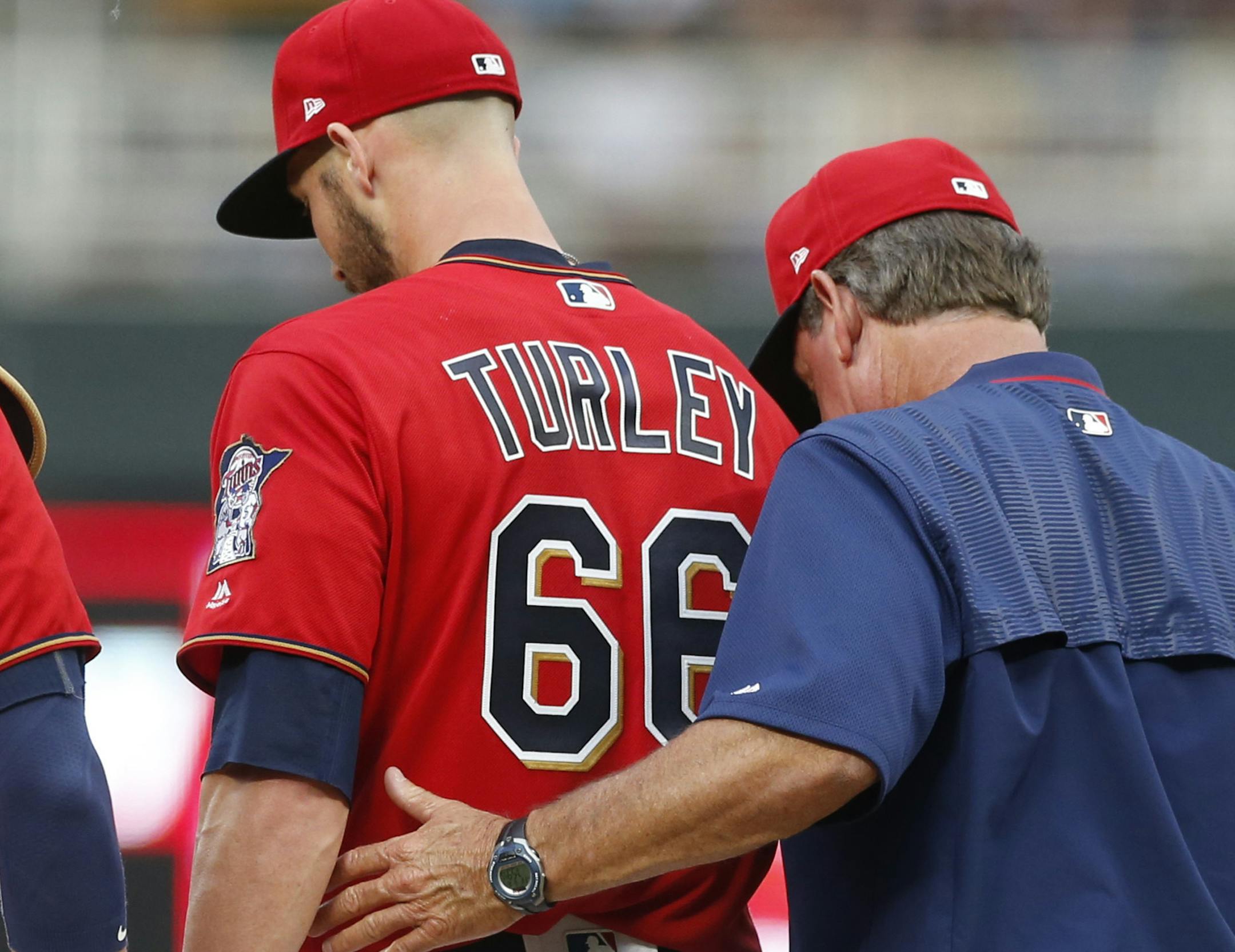 Minnesota Twins pitcher Nink Turley, center, gets support on the mound by pitching coach Neil Allen, right, in the third inning of a baseball game against the Cleveland Indians, Friday, June 16, 2017, in Minneapolis. Turley gave up four runs, including a three-run home run, in the inning. (AP Photo/Jim Mone)