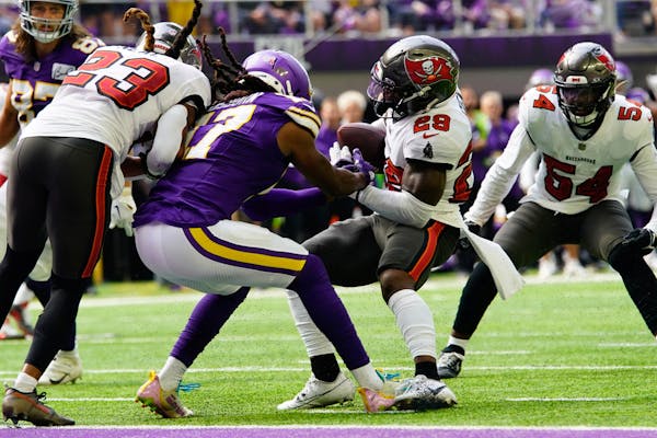 Tampa Bay Buccaneers safety Christian Izien (29) intercepts a pass intended for Minnesota Vikings wide receiver K.J. Osborn (17) during the first half