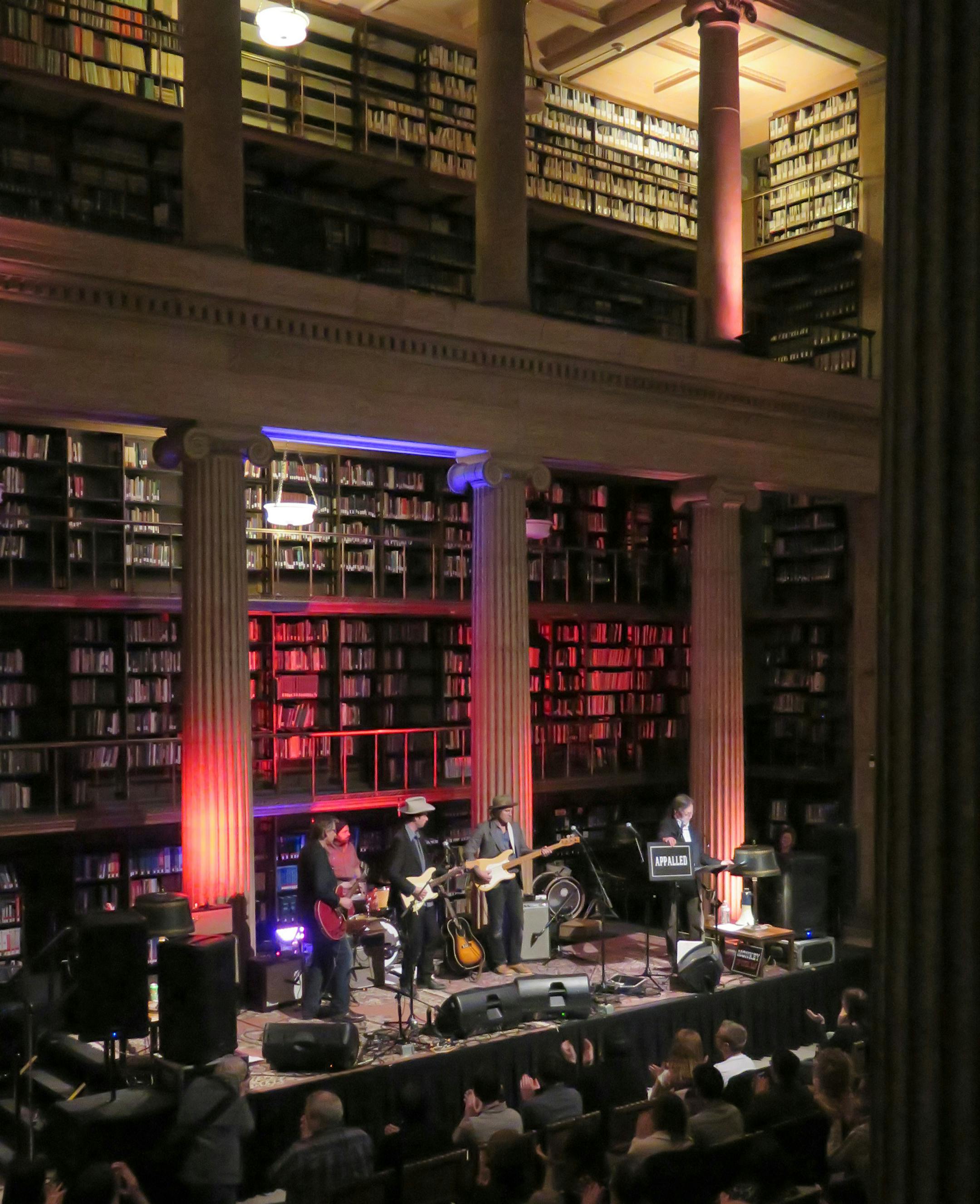Best of MN - Real Phonic Radio Hour - live performances of Americana themed music monthly at the James J. Hill Reference Library in downtown St. Paul. On stage the 'house band' led by Erik Koskinen ( white hat ) and host Thom Middelbrook, - displaying the "appalled ' (sic) sign.