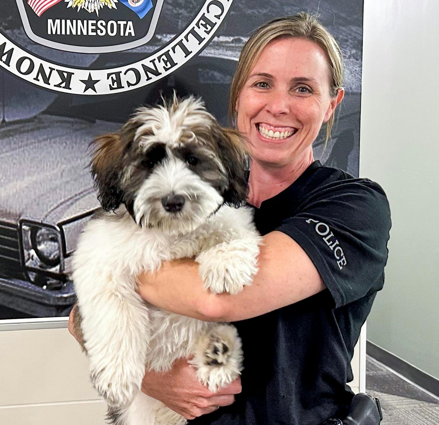 Police Detective Andrea Newton holds Doc, the Burnsville Police Department's new wellness dog.