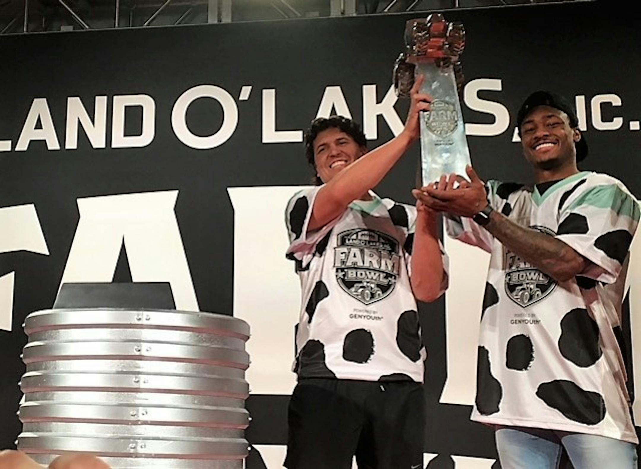 Minnesota Vikings wide receiver Stefon Diggs (right) and teammate J.J. Nunes, a farmer from Tulare, Calif., hoist the Land O’Lakes Farm Bowl Trophy on Thursday inside 3M Arena at Mariucci.