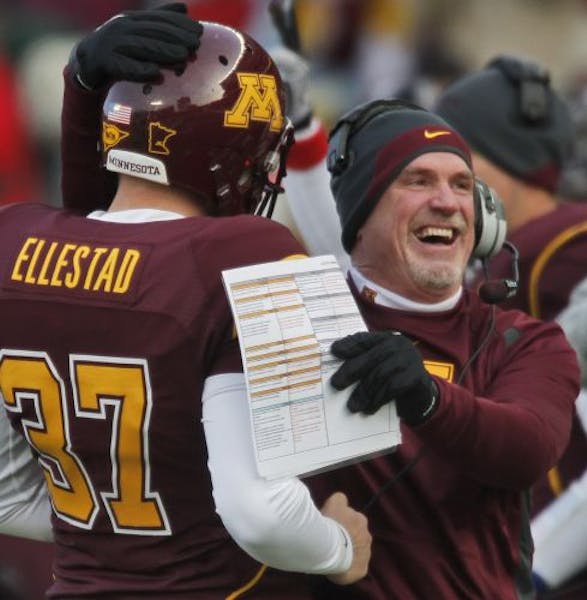 Gophers interim head coach Jeff Horton hugged Eric Ellestad after he recovered an on-side kick in first half action.