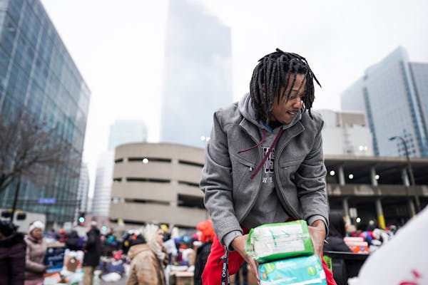 Volunteer Robert Hill of Minneapolis helped load donations onto trucks as residents were bussed to temporary shelters. ] MARK VANCLEAVE ¥ Hundreds of