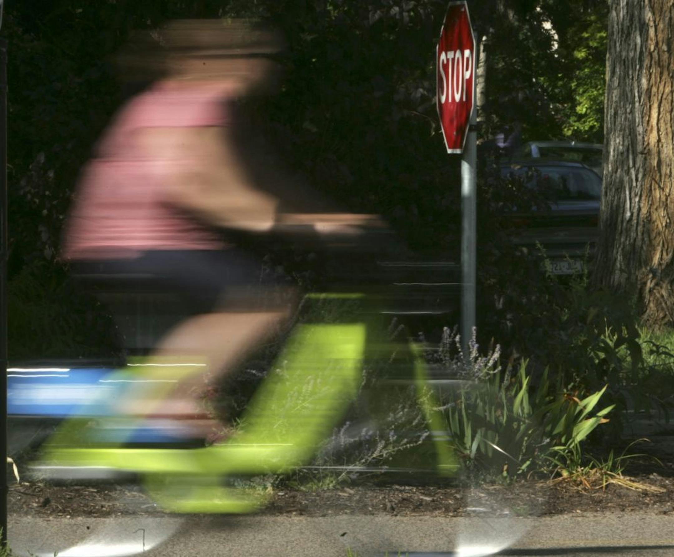 Bike commuters and recreational riders cruised through a stop sign on the Midtown Greenway in Minneapolis in 2010. Bicyclists in Washington state can now slowly roll through a stop sign if there is no oncoming cross-traffic.