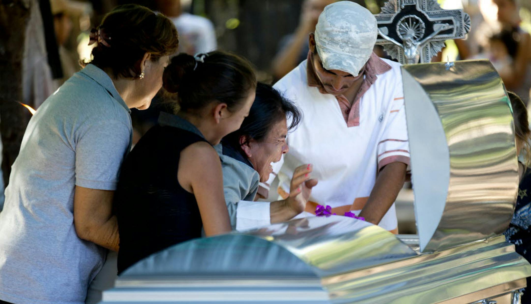 Juana Perez, third from left, cries beside the coffin of her son Rodrigo Benitez, 25, killed in the recent fighting in Antunez, Mexico.