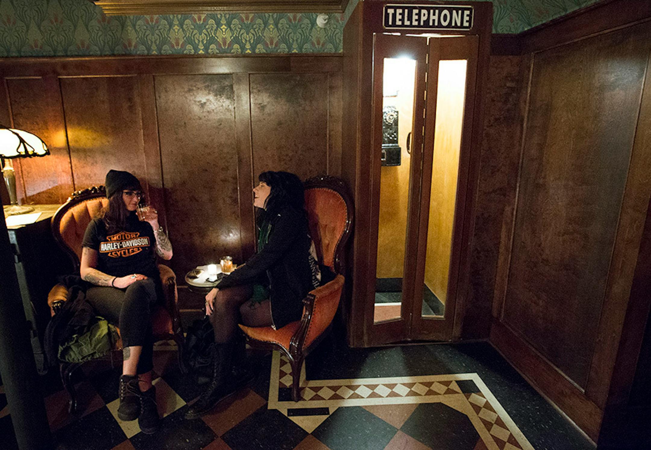 Abee LeQue, 23, and Hannah Mizer, 22, both of Minneapolis sat near a phone booth at Volstead's Emporium in Uptown.
