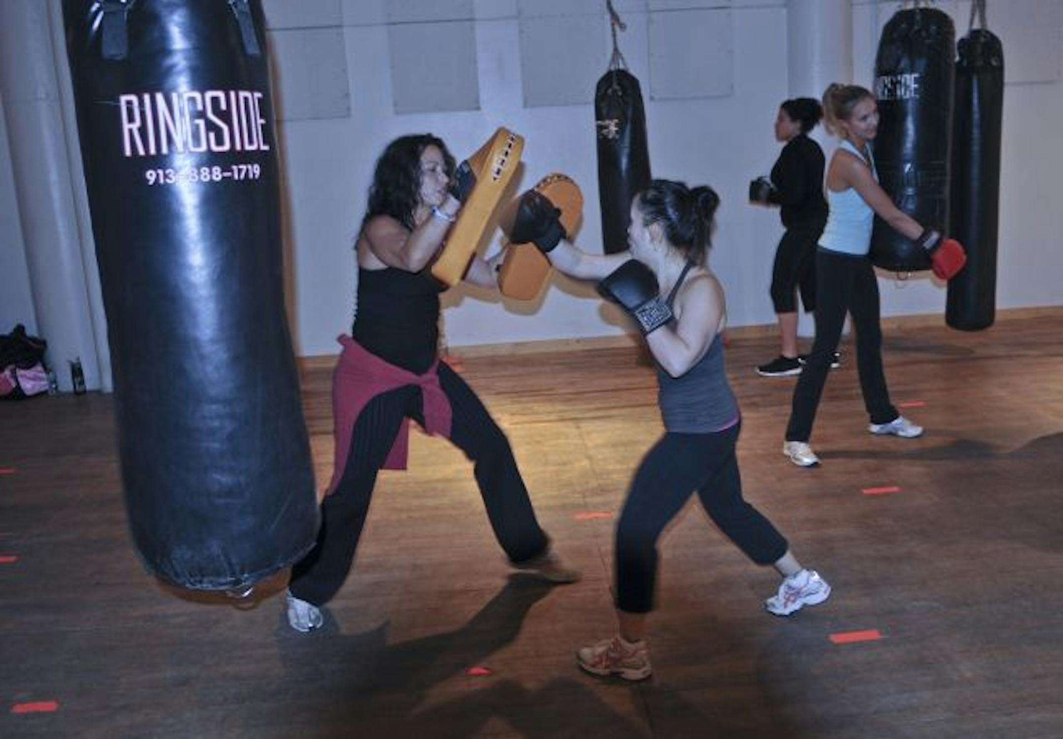 The Firm offers a class in bag boxing, which gives an all-around cardio strength-training workout. Here, Lori Fhima blocked the punches of student Mia Tellez.