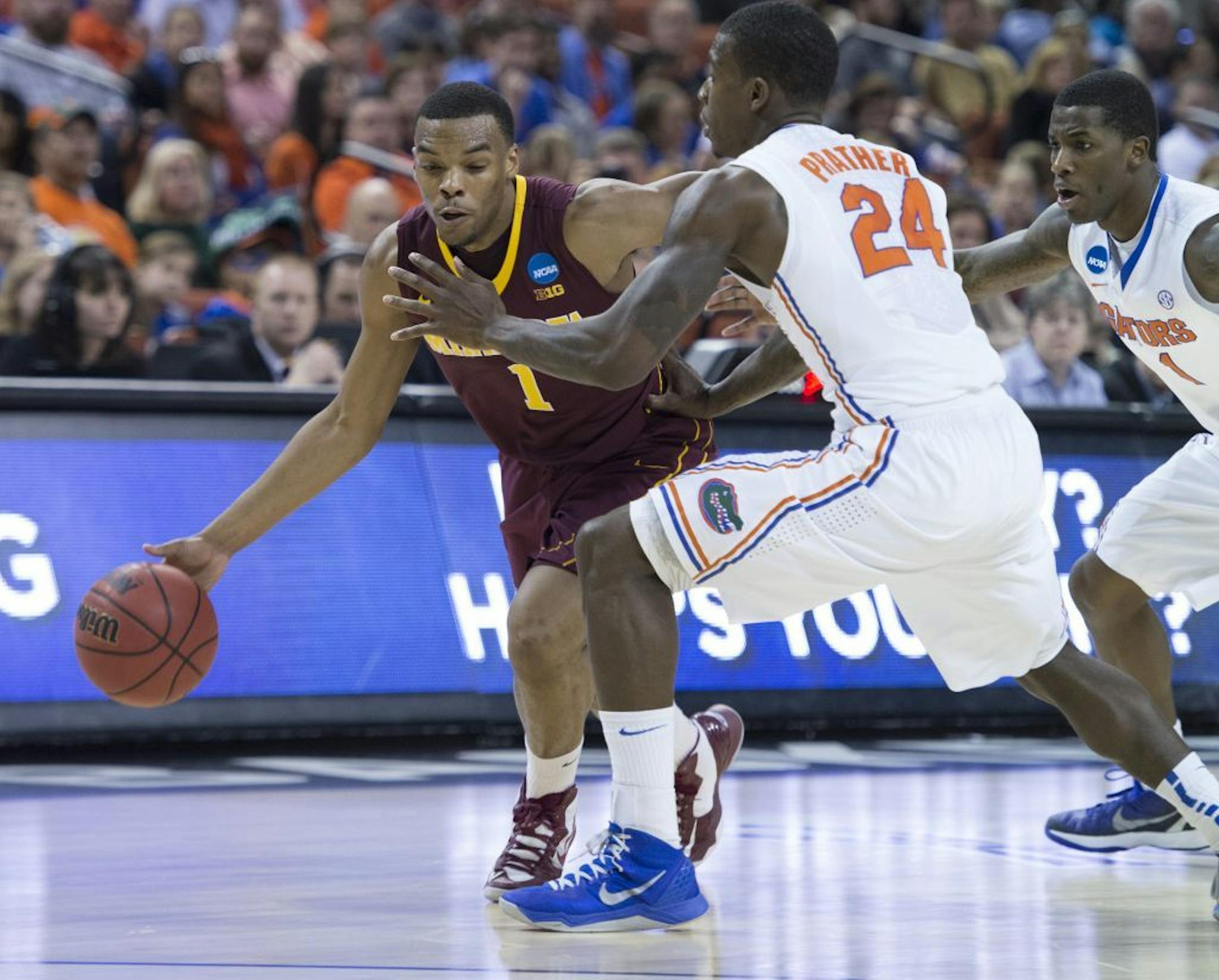 Casey Prather (24) of Florida defends Andre Hollins (1) of Minnesota as he tries to take the ball down court in the first half of their NCAA Tournament third round game on Sunday, March 24, 2013, in Austin, Texas.